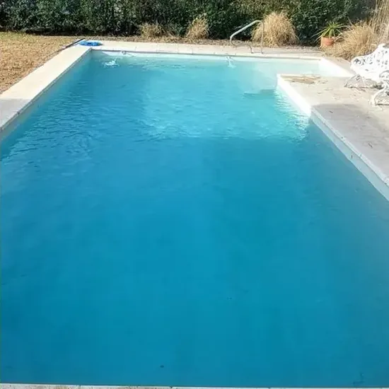 Piscina recuperada con agua transparente tras la limpieza profesional.