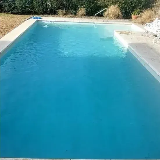 Piscina recuperada con agua transparente tras la limpieza profesional.