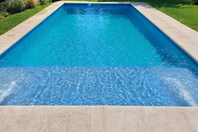 Piscina cuidada por AquaMaster con agua clara y borde limpio.